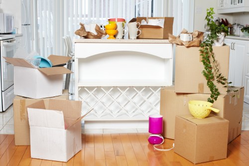 A moving team handling boxes in a Balham flat with stairs access