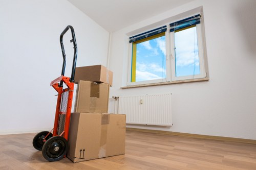 Removal crew carrying boxes down stairs in a Balham conversion flat